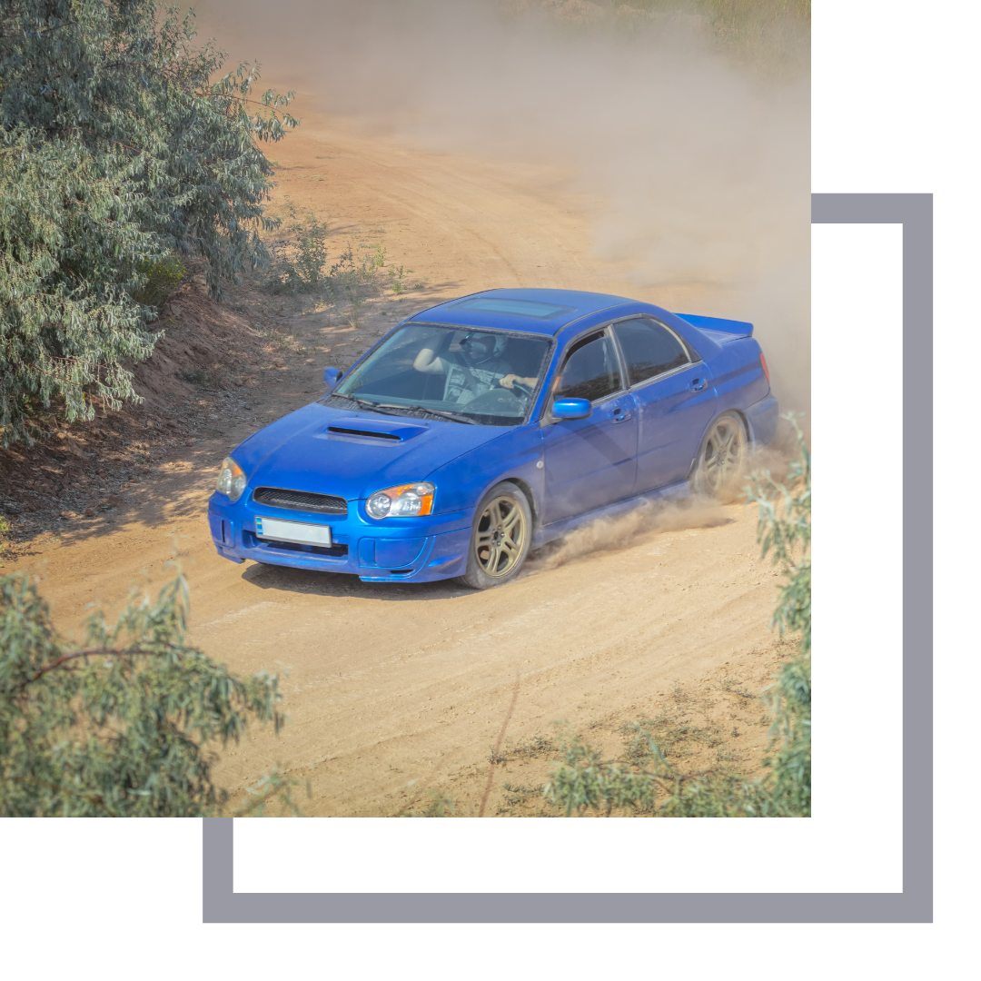 Blue Subaru rally style car on a dirt road