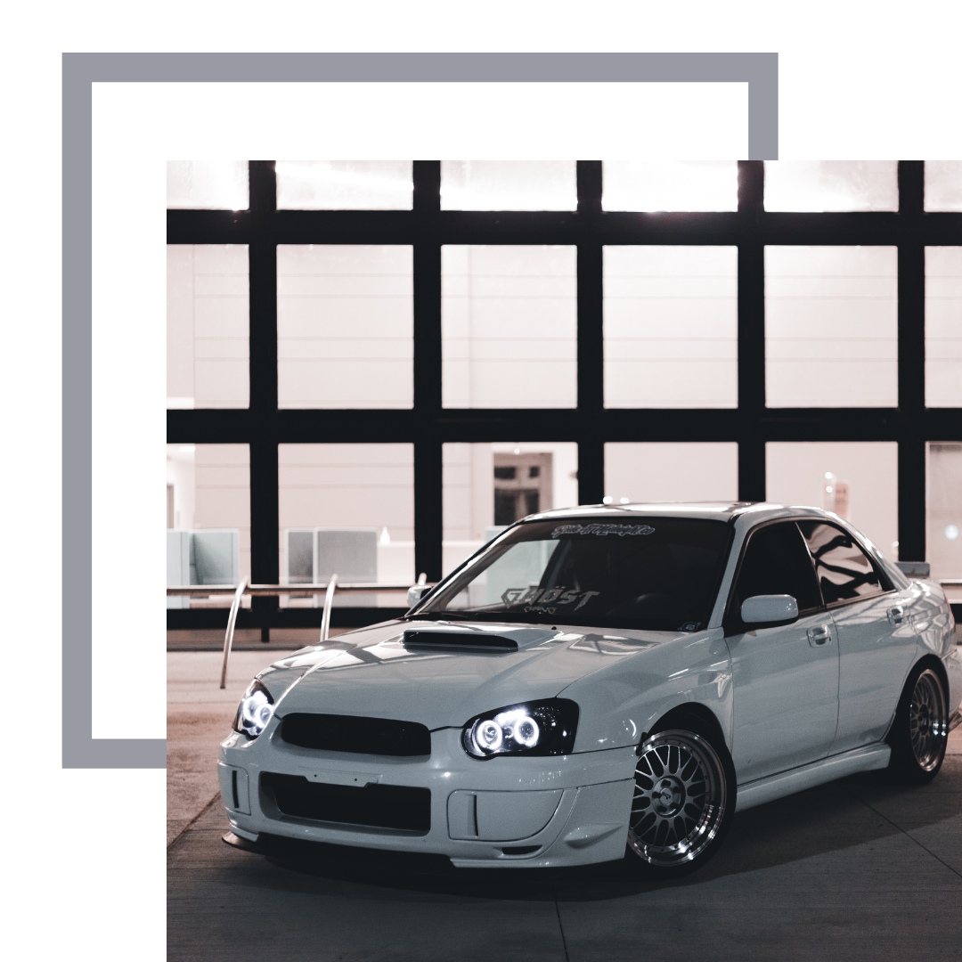 White Subaru STI with lights on