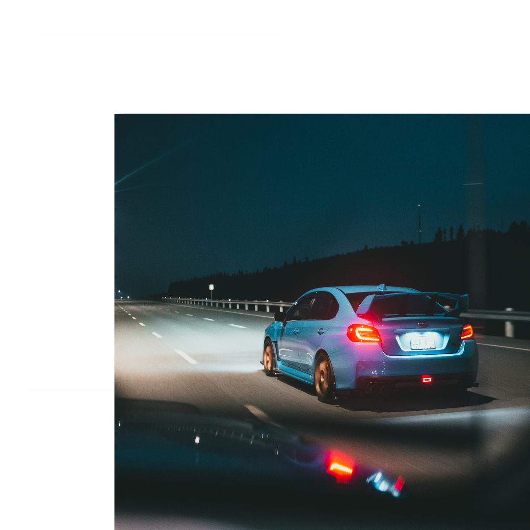 Blue Subaru driving at night